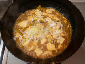 水溶き片栗粉でとろみをつけ、長ねぎを加え、胡椒を挽く