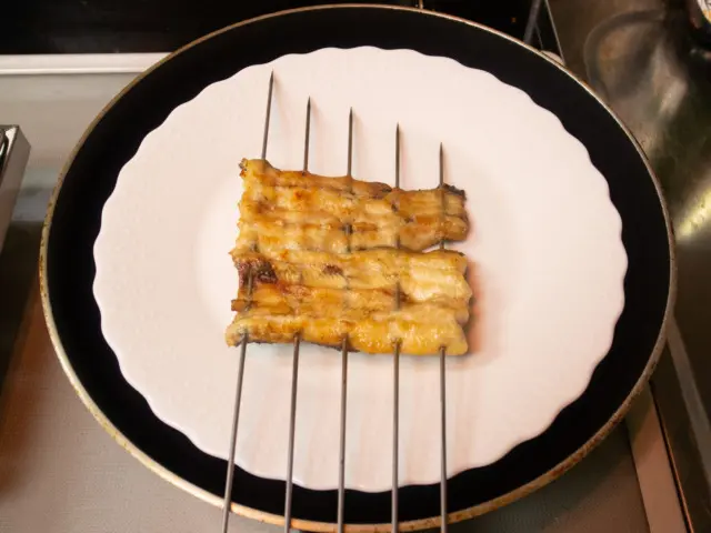 小皿の上に大きな皿を置き、ウナギをのせる