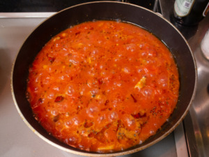 トマトを木べらで潰しながら煮る