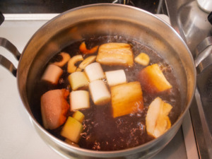 ニンニクを入れた煮汁を沸騰させて豚肉を戻す