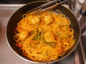 ソースとパスタを炒め合わせる