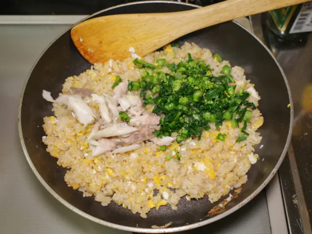 ご飯を炒めて塩胡椒をしたら、塩鯖と菜の花を加える
