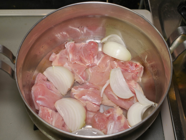 調理鍋に鶏もも肉、玉ねぎ、水を入れる