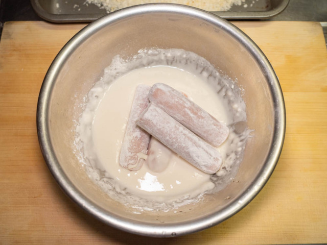 小麦粉をまぶした魚肉ソーセージとちくわにバッター液を付ける