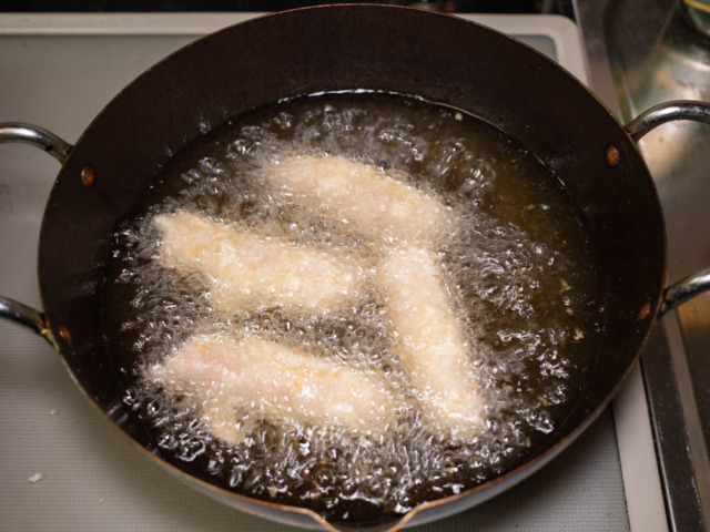 180度の油で魚肉ソーセージのフライを揚げていく