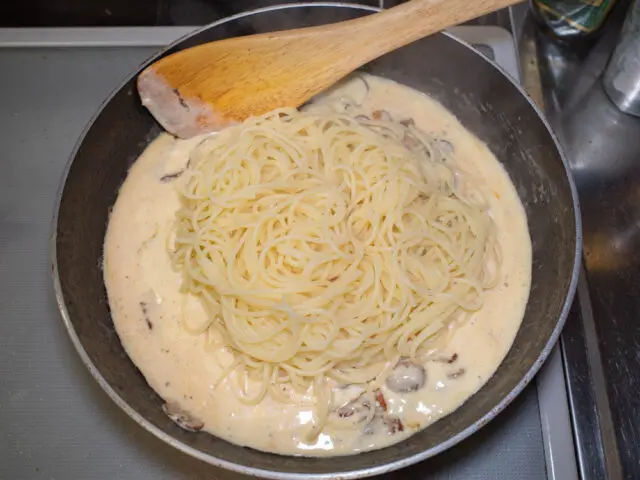 湯切りした熱々のパスタをソースのフライパンに合わせる