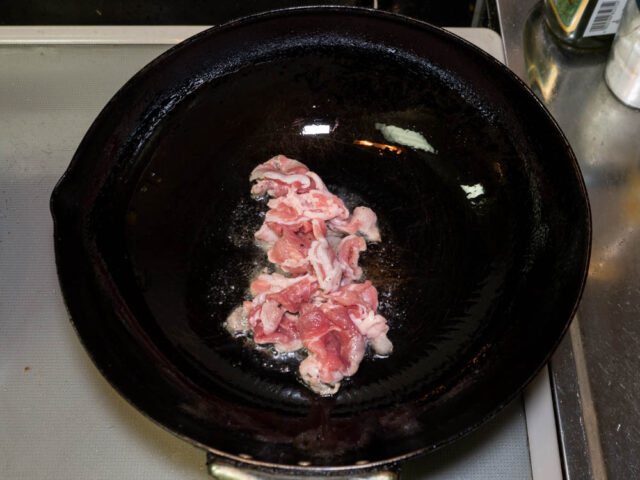 サラダ油を熱した中華鍋に豚肉を加えた写真