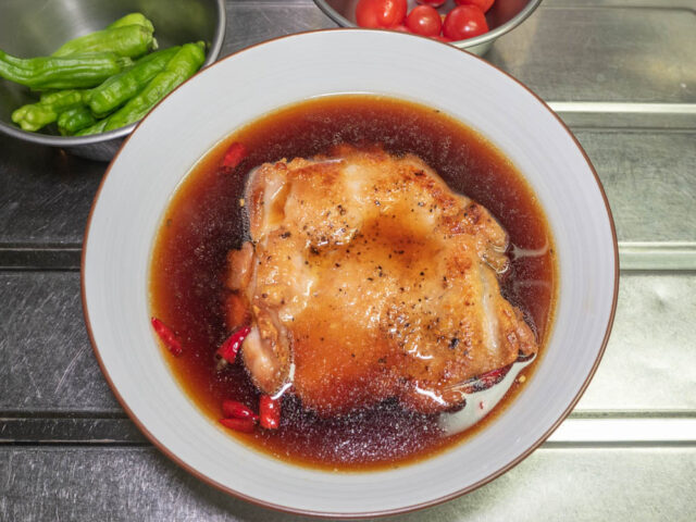 フライパンから取り出した鶏もも肉を南蛮酢に漬けた写真