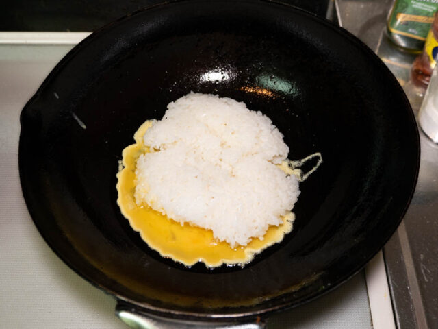 中華鍋に卵とご飯を加えた写真