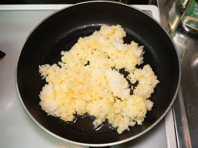 フライパンに卵かけご飯を加えた写真
