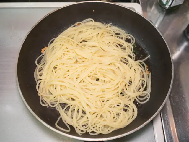 茹で上がったパスタをフライパンに合わせた写真