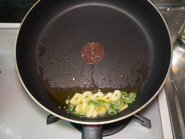 フライパンに　オリーブオイル、青唐辛子、ニンニクを入れて熱する写真