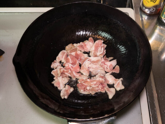 鍋にサラダ油を熱して、豚バラ肉を入れた写真
