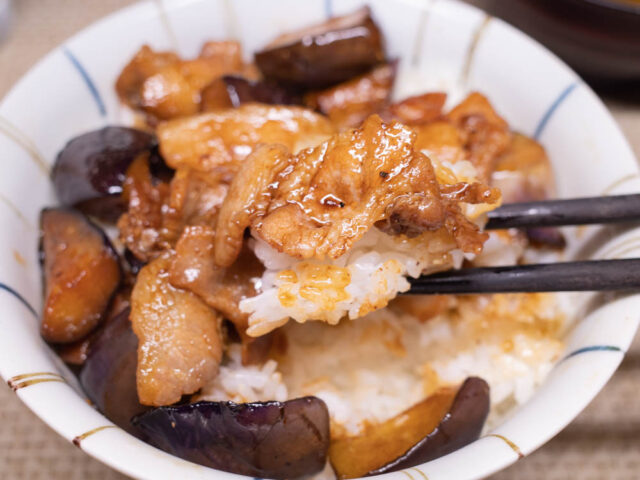 豚バラ肉とご飯を箸で持ち上げた写真
