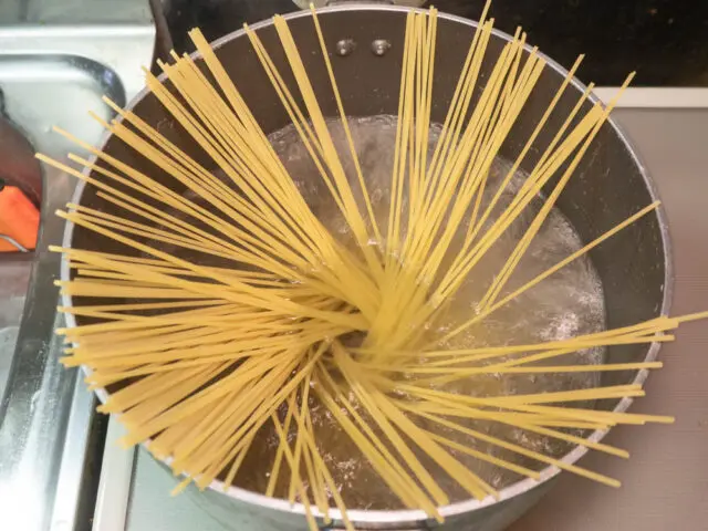 鍋にお湯を沸かしてパスタを入れた写真