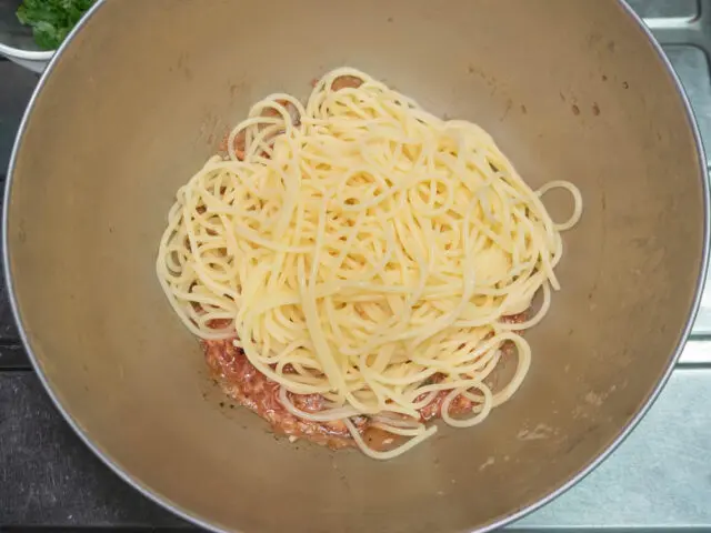 ソースのボールにパスタを加えた写真