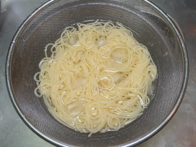 茹で上がったパスタを氷水で冷やす写真