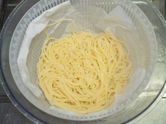 パスタをサラダ水切り器で水気を切った写真