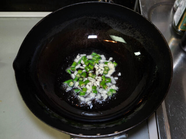 サラダ油を熱して、青唐辛子とニンニクを炒める写真