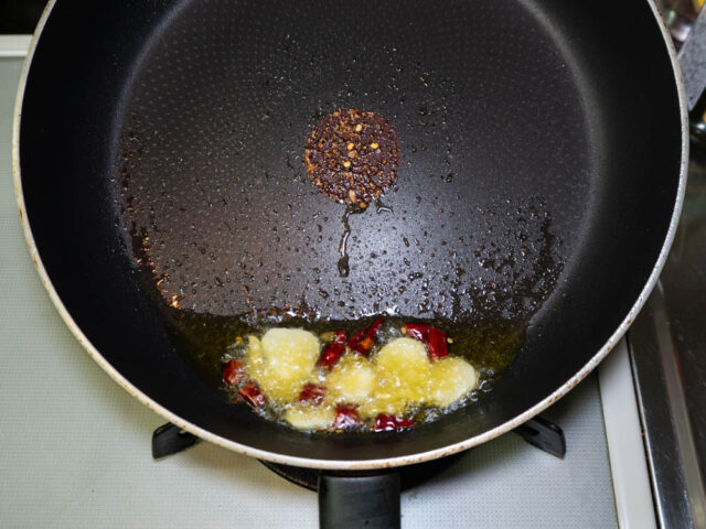 オリーブオイルを熱してニンニクと唐辛子を炒める写真
