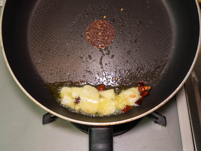 サラダ油でニンニクと唐辛子を炒める写真