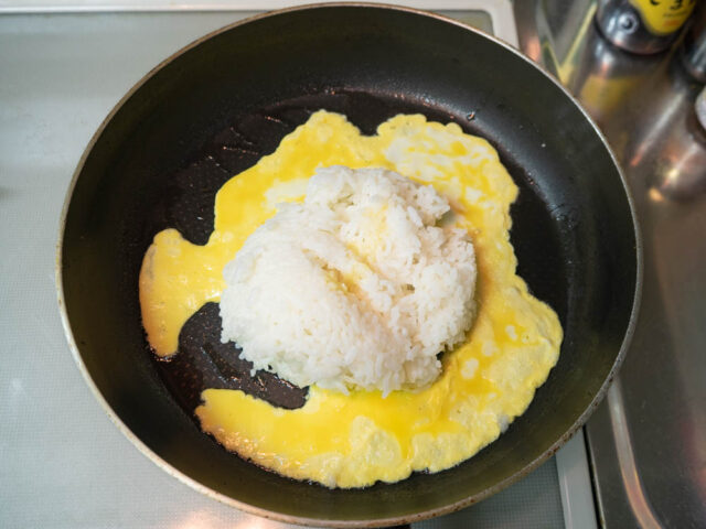 フラパンにサラダ油を熱して、卵とご飯を加えた写真