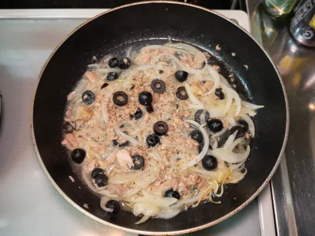 パスタの茹で汁を加え、胡椒を挽いた写真