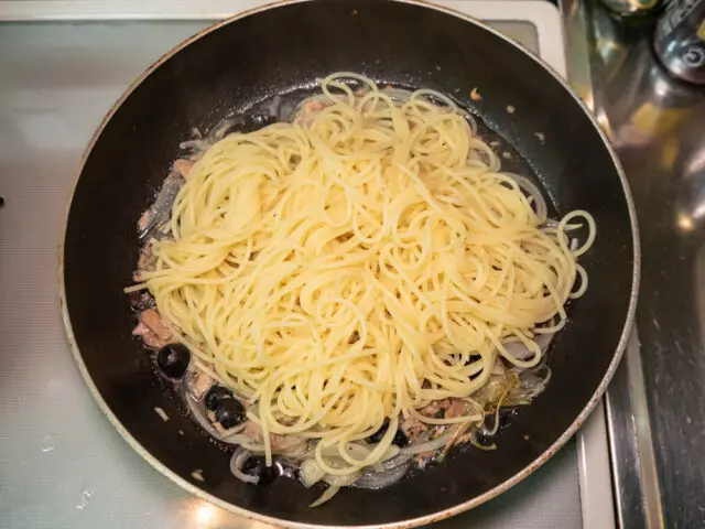 茹で上がったパスタをソースに合わせる写真