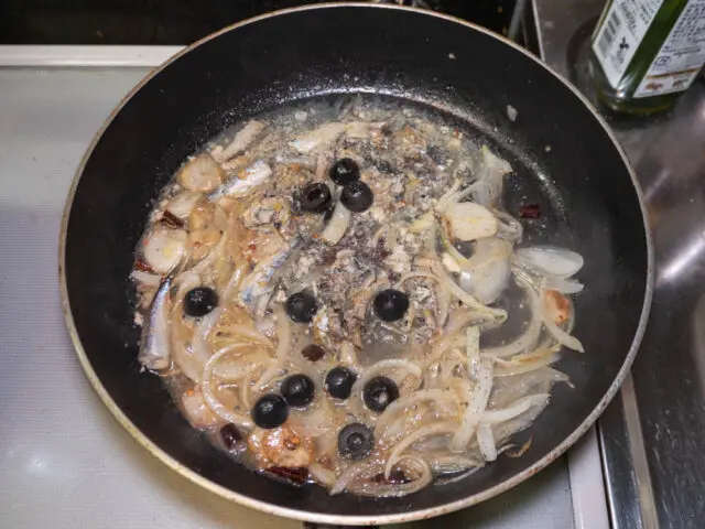 パスタの茹で汁を加え、胡椒を挽いた写真