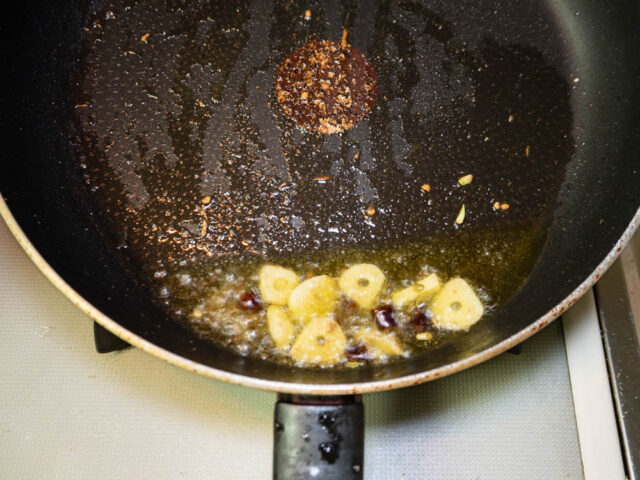 オリーブオイル、ニンニク、唐辛子、アンチョビを炒める写真