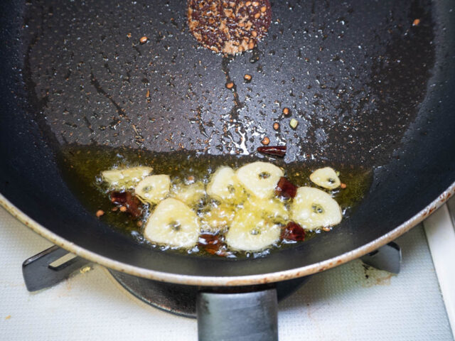 オリーブオイルでニンニクと唐辛子を加熱する写真