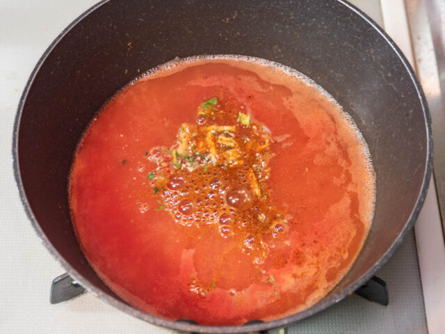 鍋に水、トマトジュースを入れて沸かし、添付のスープとかやくを加えた写真
