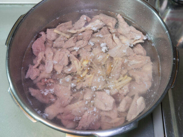 鍋に豚モツ、水、生姜を入れた写真