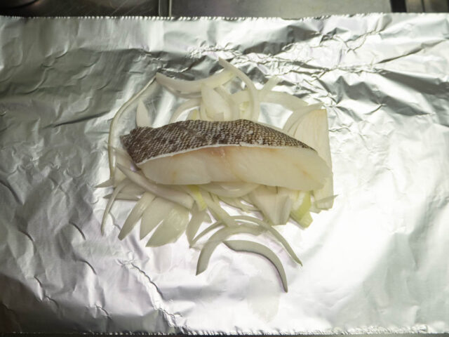 広げたアルミホイルに玉ねぎと鱈をのせた写真