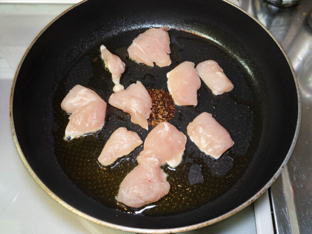フライパンにオリーブオイル、鶏胸肉を入れた写真