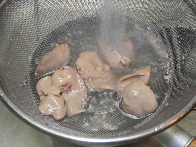 茹でた鶏レバーを流水で冷やす写真
