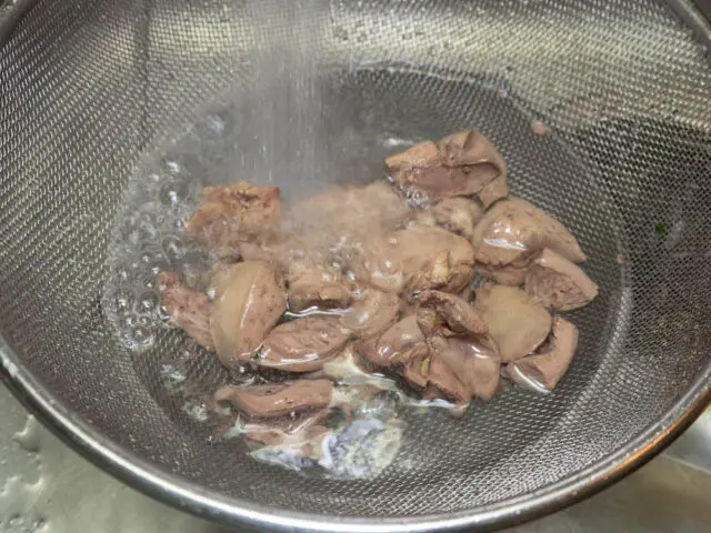 下茹でしたレバーとハツを水道の流水で洗う写真