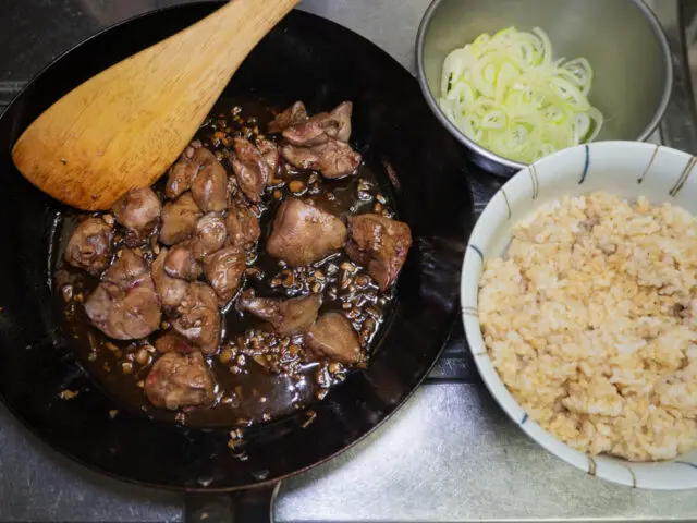 完成した鶏もつと丼ご飯、長ねぎの写真