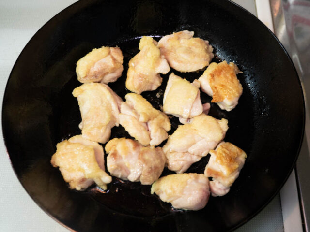 焼き色が付いた鶏もも肉をひっくり返した写真