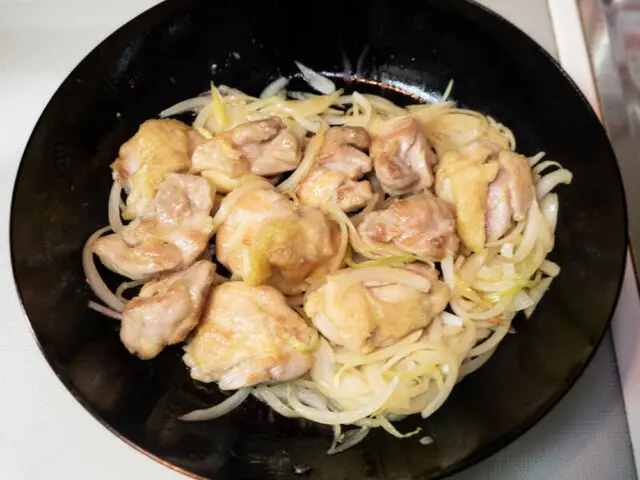 鶏肉と玉ねぎを炒め合わせる写真