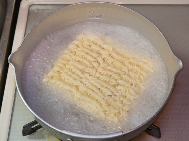 鍋にお湯を沸かし、インスタント麺を入れた写真