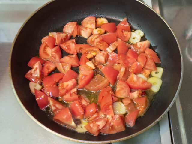 フライパンにトマトを加えた写真