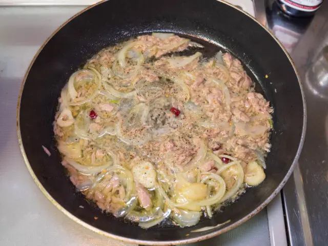 パスタの茹で汁を加え、胡椒を挽いた写真