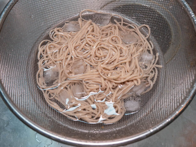 茹でたお蕎麦を氷水で冷やす写真