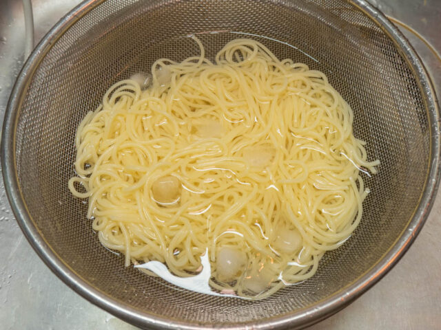 茹で上がったパスタを氷水にひたす写真