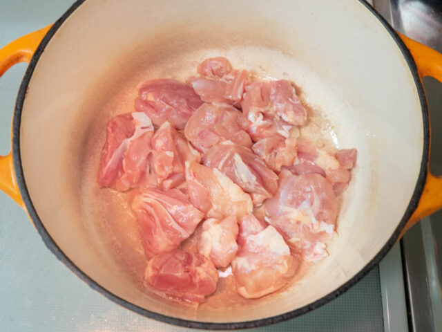 鍋にサラダ油を熱して、鶏もも肉を並べ入れた写真