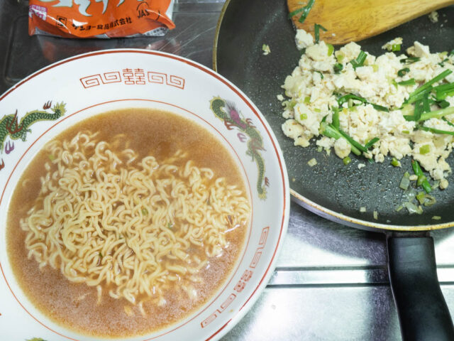 できたラーメンが入った丼と、炒りニラ豆腐のフライパンを並べた写真