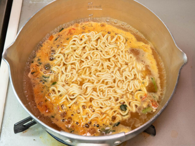 鍋にお湯を沸かし、スープと麺を入れた写真