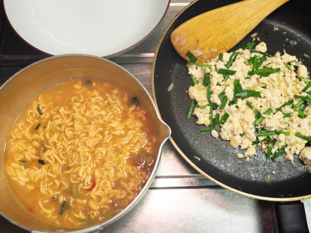 鍋のラーメンと、フライパンの炒りニラ卵と丼の写真