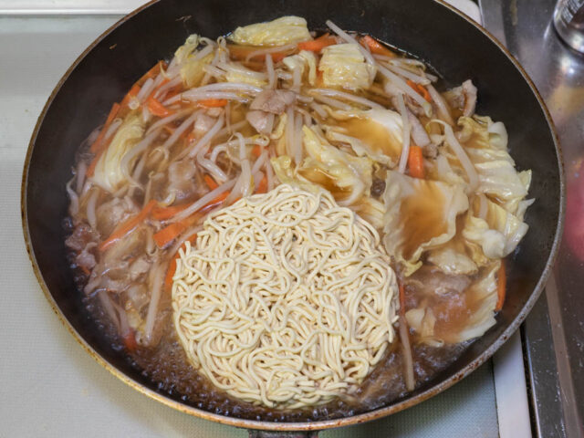 スープが沸騰してインスタント麺を加えた写真